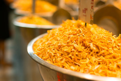 Close-up of orange spices in container for sale at market stall