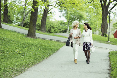 Full length of senior women walking on garden path