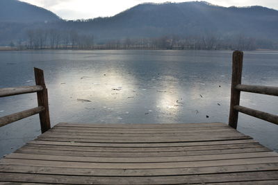 Pier over lake against mountains