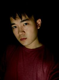 Portrait of young man against black background