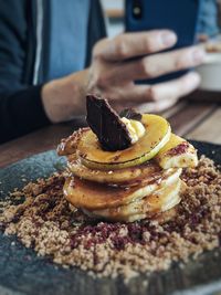 Close-up of human hand photographing food on table