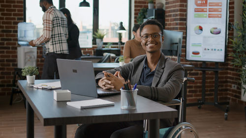 Portrait of woman using laptop at cafe