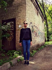 Full length of woman standing against wall