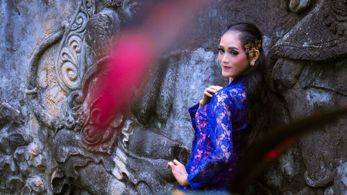 Portrait of a beautiful young woman against wall