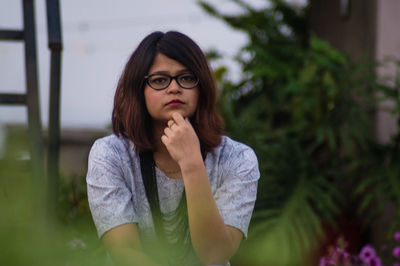 Portrait of young woman against blurred background