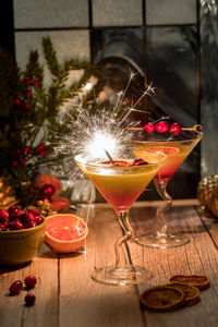 A cranberry and orange mimosa with a sparkler for a festive celebration.