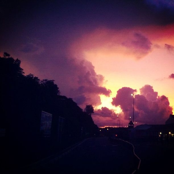 sunset, sky, cloud - sky, silhouette, built structure, building exterior, architecture, road, cloudy, the way forward, tree, dusk, transportation, dramatic sky, orange color, cloud, street, beauty in nature, nature, scenics