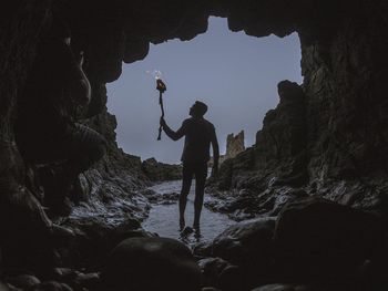 Man with flaming torch walking in cave