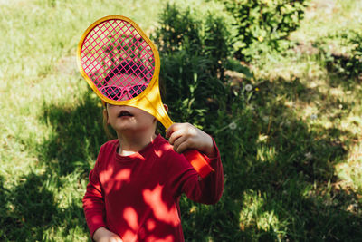 Girl in sunglasses looks at the sun through a racket. expression of emotion