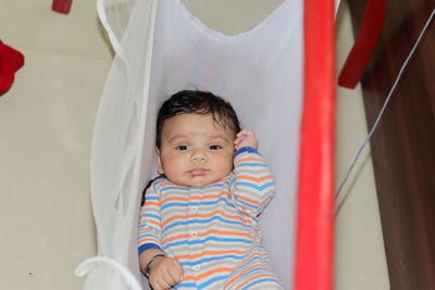 Close-up of an indian little newborn innocent baby thinking while sleeping in the crib indoor