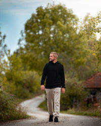 Portrait of young man standing on road