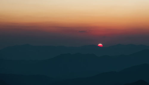 Scenic view of silhouette mountains against sky during sunset