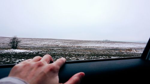 Cropped image of person seen through car window