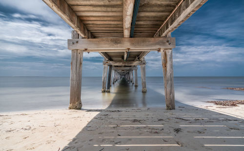 View of pier on beach against sky