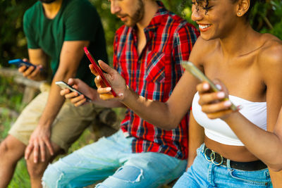 Midsection of couple holding mobile phone