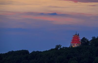 Illuminated pagoda against sky during sunset