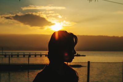 Close-up of silhouette woman at beach during sunset