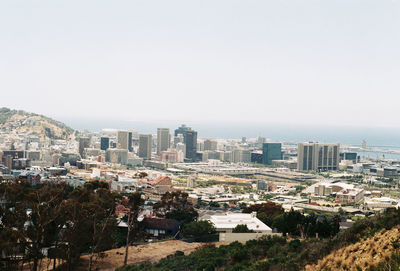 High angle view of buildings and sea against clear sky