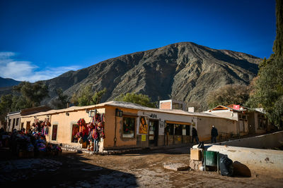 People on mountain against blue sky