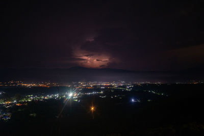 High angle view of illuminated city against sky at night