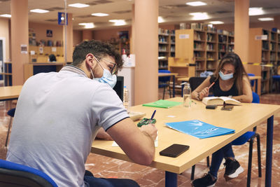 A couple studies at university while keeping a safe distance