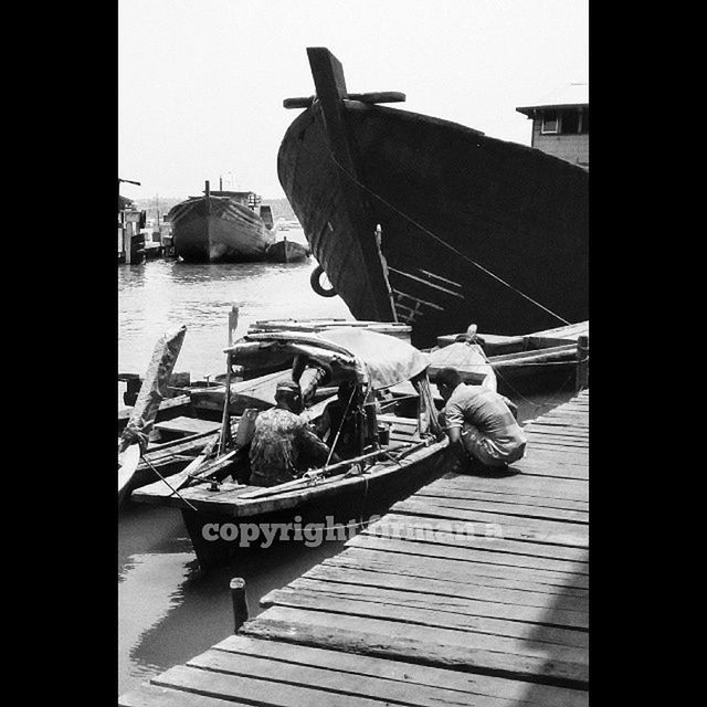 text, clear sky, wood - material, day, animal representation, western script, water, transfer print, outdoors, art and craft, auto post production filter, no people, art, wood, communication, built structure, transportation, sunlight, close-up, nautical vessel