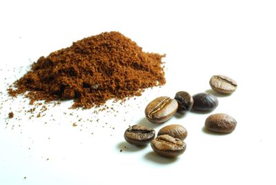 High angle view of coffee beans against white background