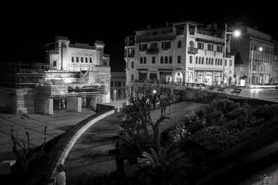 Street amidst illuminated buildings in city at night