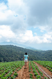 Full length of woman standing on agricultural field against sky