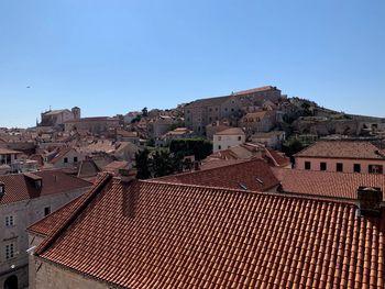 Buildings in city against clear blue sky