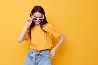 Teenager girl wearing sunglasses against colored background