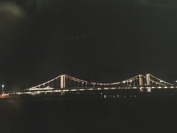 Golden gate bridge over river against sky at night
