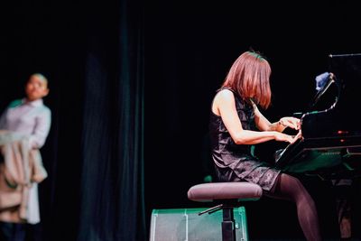 Woman playing piano on stage