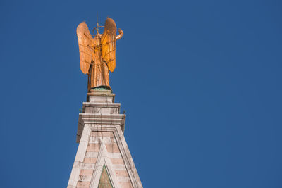 Low angle view of statue against clear blue sky