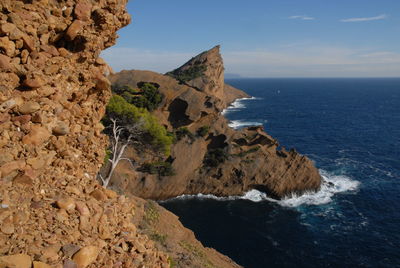 Rock formations by sea against sky