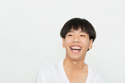 Portrait of smiling young man against white background