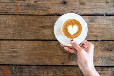 Directly above shot of woman holding coffee cup