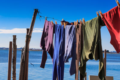 Clothes drying on clothesline against seascape