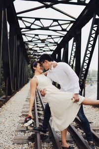 Young couple standing on bridge