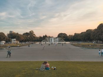 People on land against sky during sunset