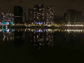 Reflection of illuminated buildings in city at night