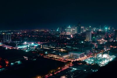 High angle view of city lit up at night
