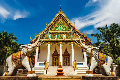 Statue of temple against building and sky