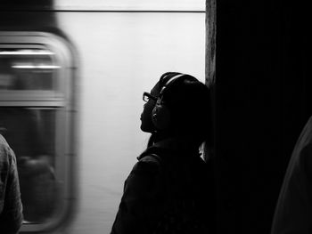 Side view of woman standing in train at subway station