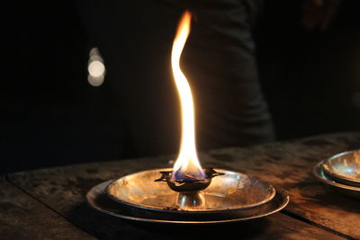 Close-up of illuminated candle on table