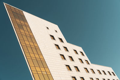 Low angle view of modern building against clear blue sky