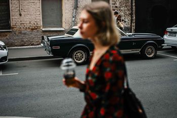 WOMAN STANDING ON ROAD IN CITY