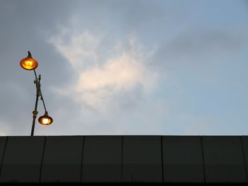 Low angle view of illuminated street light against building