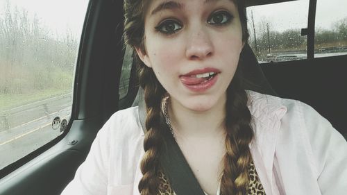 Close-up portrait of young woman in car