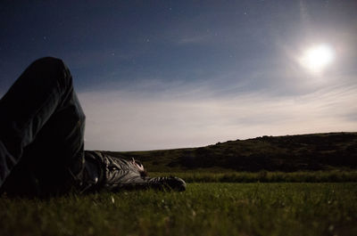 Man with umbrella against sky at night